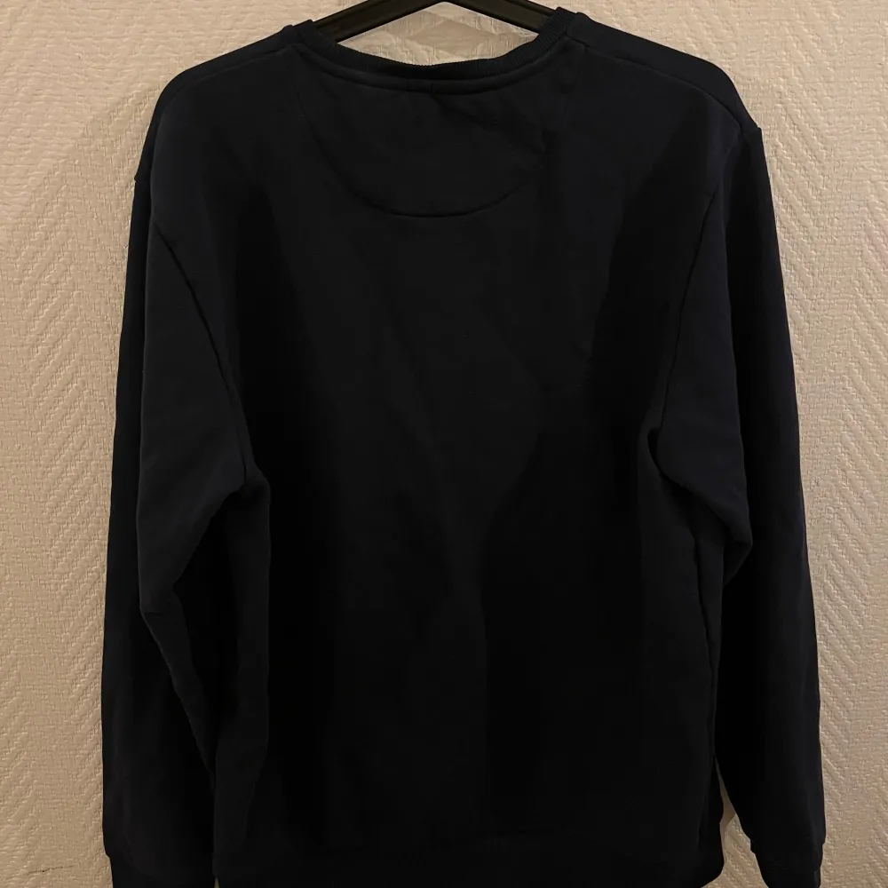 Säljer en stilren svart tröja från Lyle & Scott med deras logga diskret på bröstet. Tröjan har långa ärmar och en rund halsringning. Perfekt för en avslappnad look. Passar L/M✅ pris:130kr✅. Neuletakit & Villapaidat.