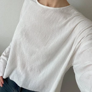 Vit långärmad topp - Säljer vit långärmad topp med en lös passform. Toppen har en enkel design med rund hals och är tillverkad i ett lätt och luftigt material. 