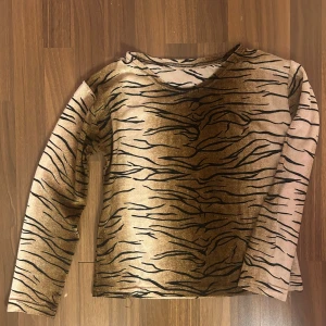 y2k topp - Häftig topp i tigermönster. Köpt på vinted, använd en gång. Tröjan verkar vara lite äldre, det finns inget märke på. Säljer för den är lite liten (har för långa armar😪). Jättesöt!!
