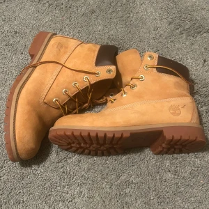 Bruna boots från Timberland - Säljer ett par klassiska bruna boots från Timberland med snörning och robust sula. Perfekta för höst och vinter med sin slitstarka design och bekväma passform.