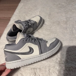 Grå och vita Nike Air Jordans - Snygga Nike Air Jordans i grått och vitt med klassisk snörning. Perfekta för en stilren look med ikonisk design och bekväm passform.