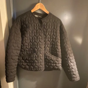 Svart quiltad jacka från Zara - Snygg svart quiltad jacka från Zara med rund hals och knappar framtill. Den är relativt tunn och passar perfekt nu till våren. Jag har använt den några gånger men den är i fint skick. Den har en liten defekt på framsidan så att ni vet!❤️
