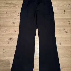 Svarta lågmidjade kostymbyxor - Snygga svarta kostymbyxor med en klassisk design. Byxorna har en rak passform och är perfekta för en stilren look. Storlek L men passar m🤗.