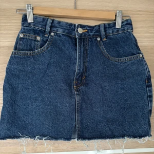 Blå jeanskjol med fransig kant - Snygg blå jeanskjol från Pull&Bear! Använd fåtal gånger och inga defekter❣️ 