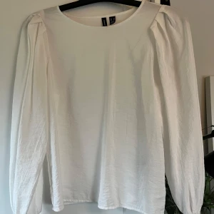 Vit blus från Vero Moda - Säljer en stilren vit blus från Vero Moda med långa ärmar och rund hals. Blusen har en luftig passform💕                 Den är i storlek XS💕