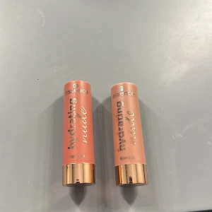 Essence Hydrating Nude Läppstift - Två läppstift från Essence i serien Hydrating Nude. Nyanserna är 302 'Heavenly' och 303 'Delicate'. De har en krämig konsistens och ger en naturlig look. Förpackningen är elegant med en roséguldig hylsa. Det är ungefär hälften kvar i båda. Nypris är 35kr styck 