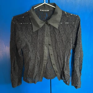 Svart spetsblus från Kaffe - Snygg svart spetsblus från Kaffe med långa ärmar och knappar framtill. Super chic och väldigt snygg passform. Knappt använt🥰