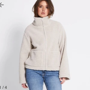 Beige teddyjacka med dragkedja - Mysig beige teddyjacka med hög krage och hel dragkedja framtill. Jackan har två stora fickor och är tillverkad i fluffigt teddy-material som ger en chill och avslappnad vibe. Perfekt för lager-på-lager och passar till jeans eller mjukis.