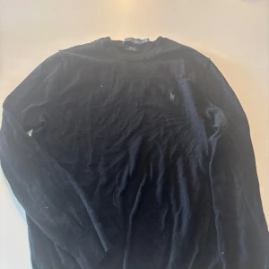 Ralph lauren tröja  - Svart långärmad tröja från Polo Ralph Lauren i slim fit med broderad logga på bröstet. Tillverkad i mjuk och tvättbar merinoull, bra skick inte sliten, använd ca 10 tillfällen. 