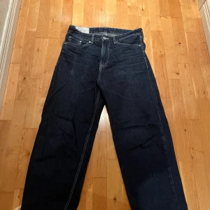 Loose fit jeans från H&M, mörkblå - Mörkblå jeans från H&M i loose fit-modell. Klassisk femficksdesign med raka ben och kontrastsömmar. Tillverkade i bomull för en skön och avslappnad känsla. Perfekta för dig som gillar en lite mer baggy stil.