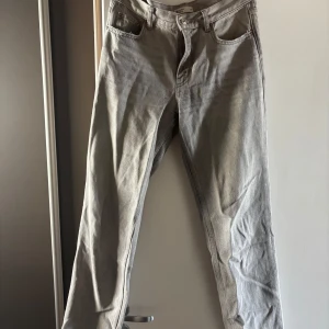 Gråa baggy jeans från ginatricot  - Säljer ett par klassiska baggy jeans jeans i grått. De har rak passform, fem fickor och knappgylf. Jeansen är tillverkade i robust denim och har en tidlös look som funkar till det mesta. Perfekta för dig som gillar en clean och avslappnad stil.