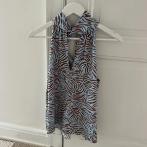 Zebramönstrad ärmlös topp från Zara - Säljer en topp från Zara med blått och brunt zebramönster. 