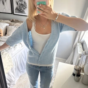 Ljusblå stickad kofta med kort ärm - Superfin ljusblå stickad kofta med korta ärmar och v-ringning. Aldrig använd 