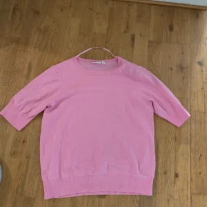 Rosa stickad tröja från Kappahl - Säljer en ljusrosa stickad tröja från Kappahl i storlek M. Tröjan har rund halsringning och halvlånga ärmar. Den är enkel och stilren med ribbade muddar vid ärmslut och nederkant. Perfekt för dig som gillar en mjuk och bekväm look.