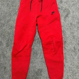 nike tech  - Riktigt snygga röda mjukisbyxor från Nike med svart logga på låret.Byxorna är nya, har aldrig använt dem. 