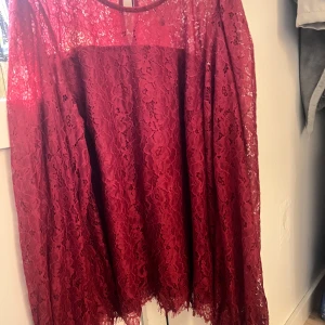 Vinröd spetsklänning Hampton Republic - Supersnygg vinröd kortklänning från Hampton Republic i spets med blommigt mönster. Klänningen har rund halsringning och är helfodrad med transparenta ärmar. Perfekt för dig som vill sticka ut med en elegant och trendig look.