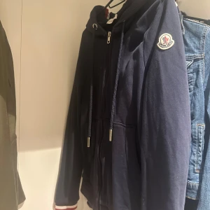 Mörkblå kofta från Moncler - Snygg mörkblå kofta från Moncler med dragkedja, det finns också en scan på tröjan. Den är i jätte bra skick.