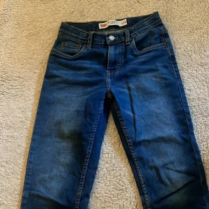 Levi's 502 mörkblå jeans 12A - Snygga Levi's 502 Regular Taper jeans i mörkblå tvätt. Klassisk femficksmodell med taperad passform och normal midja. Jeansen har Levi's ikoniska läderpatch bak och röda logotagg på bakfickan. Perfekta för en avslappnad och stilren look.