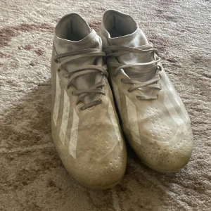 Adidas CrazyFast/X Elite - Säljer ett par snygga vita fotbollsskor från Adidas med klassiska vita ränder på sidorna. Skorna har snörning och en strumpliknande krage för extra stöd. Har inte påsen, har använt de över ett år nu så kan vara smutsigt  men man kan tvätta skorn.Den är också oskadad.Pris kan också diskuteras.