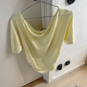 Tröja - Snygg ljusgul topp från 157 med korta ärmar och en draperad, lite djupare halsringning. Använd en gång.