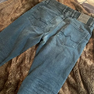 Blå jeans från Alberto med raka ben - Snygga blå jeans från Alberto regular slim fit med klassisk femficksdesign och raka ben. Jeansen har subtila slitningar och en mörkblå ton med lätt tvättad look. Materialet är jeans och passformen är normal, perfekt för en chill och stilren vibe.