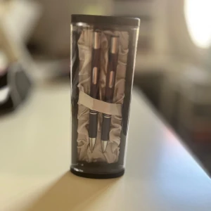 Pennset - Pris kan diskuteras.                                          Bilderna visar ett elegant pennset med två pennor i en lyxig presentförpackning. Perfekt för dig som vill skriva snyggt i skolan, på jobbet eller till dagboken. Pennorna har en modern design med metallfärgade detaljer och ligger i en silkeslen bädd. Ett stilrent tillbehör för unga kreatörer och studenter.