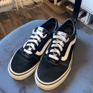 Svarta Vans Old School sneakers - Säljer ett par klassiska Vans Off The Wall skor i svart o vit! Dem är i storlek 38 och är i ganska bra skick. Det finns lite skavanker på sidan av sulan på skon (bild 4&5) och de röda märket bak har åkt bort lite, men inget som jag tycker förstör skon eller är till besvär. Säljer billigt med tanke på de små skadorna.  Hör av dig om du har frågor om pris eller annat! :) Nypris=800