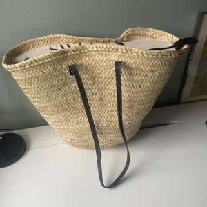 Strandväska  - Stor och rymlig strandväska från Sweeks med måtten 35x52x17 (HxBxD). Sparsamt använd, på vissa ställen har basten gått upp lite. Nypris 500