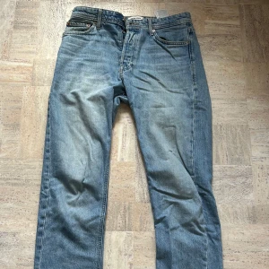 Jack & Jones Loose fit jeans blå - Säljer ett par ljusblå jeans från Jack & Jones med loose fit och klassisk femficksdesign. Modellen heter Loose/Chris och har raka ben med normal passform. Jeansen är tillverkade i bomull och har snygga slitningar för en chill look.