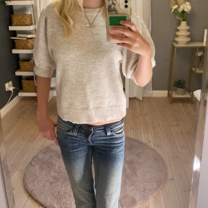 Beige stickad tröja Gina Tricot - Säljer en beige stickad tröja från Gina Tricot i storlek 170. Tröjan har puffiga halvlånga ärmar och ribbade muddar vid ärmslut och nederkant. Den är mjuk och har en avslappnad passform, perfekt för dig som gillar enkel och stilren look.