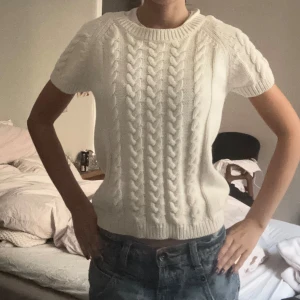 Vit stickad tröja Odd Molly - Supersöt vit stickad tröja från Odd Molly med korta ärmar och flätstickat mönster både fram och bak. Rund halsringning och snygg snörning i nacken. St xs-s men skulle kunna passa m också