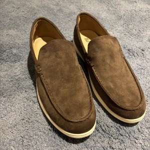 Bruna mockaloafers - Snygga bruna loafers med vit platt sula. Skorna har en klassisk, stilren design med rund tå och mjukt innermaterial. Perfekta för dig som gillar en chill och clean look med lite dressad vibe. Inget kvitto eller box medföljer!