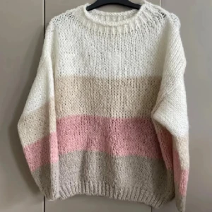 Randig stickad tröja i mohairmix - Supermysig stickad tröja med breda ränder i vitt, beige och ljusrosa. Tröjan har rund hals och lång ärm, och är gjord i en mjuk mohairmix med ull, nylon och akryl. Perfekt för dig som gillar chill och comfy vibes.