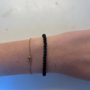 Svart pärlarmband med facetter - Stilrent armband med svarta, facetterade pärlor som ger en snygg glans. Armbandet är elastiskt och passar de flesta handleder. Perfekt accessoar för att lyfta din outfit med en enkel men cool detalj. Handgjort 