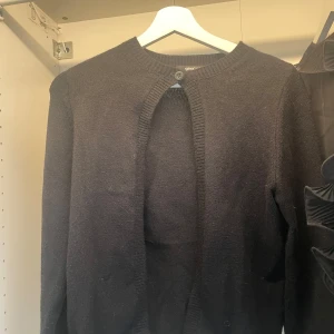Svart kofta från Gina Tricot XS - Svart, klassisk kofta från Gina Tricot i storlek XS. Koftan har rund halsringning, ribbade muddar och en knapp upptill. Materialet är stickat och mjukt, perfekt för lager-på-lager. Enkel och stilren design som funkar till många outfits.