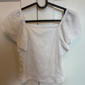 Vit  blus från Kappahl - Söt vit blus från Kappahl i storlek 158/164. Modell med korta, luftiga ärmar och broderade hålmönster över hela tyget. 