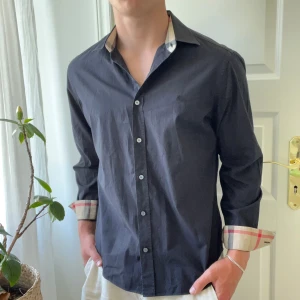 Burberry skjorta - Feett, Burberry skjorta i size L. Modellen är 180,75 kg. Skjortan är i väldigt bra skick med inga defekter. Kom med frågor!