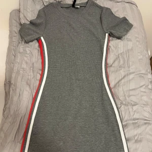 Grå ribbad klänning - Säljer en grå ribbad klänning från h&m i storlek 36. Klänningen har en tight passform och ger en superfin passform. Den är i nyskick och säljs för 129kr.