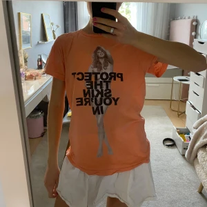 Persikofärgad Marc Jacobs T-shirt med tryck - Säljer denna unika 'Protect the skin you're in' t-shirt från Marc Jacobs med Kate Upton, som inte säljs längre. 