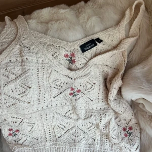 Fin topp  - Superfin virkad linnetopp i vitt från Kappahl med broderade röda och rosa blommor.