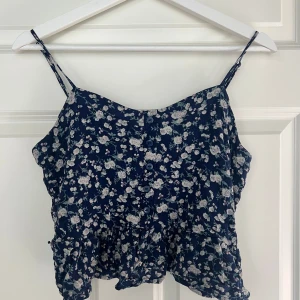 Blommig linnetopp från Bik Bok - Jättesöt marinblå topp från Bik Bok med vitt blommönster och lite volang nertill❤️ Tycker att den passar mer i storlek XS och inte M. Säljer för att jag har tröttnat lite på den och blivit lite förliten. Men tycker fortfarande att den är så fin❤️