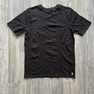 Svart t-shirt från Polo Ralph Lauren - Klassisk svart t-shirt från Polo Ralph Lauren med liten broderad logga nertill. Enkel och stilren design med rund hals och korta ärmar. Aldrig använd då den var för stor. Köp alla te i min profil för 420:-🫰