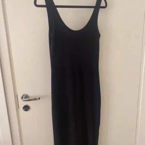 Svart ribbad långklänning  - Säljer en svart ribbad långklänning. Klänningen är ärmlös med rundad halsringning och har en tight passform. 
