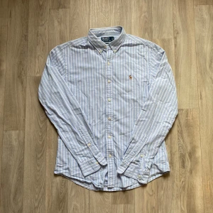 Ralph Lauren skjorta - • Säljer en blå och vit randig skjorta från Ralph Lauren  • Skjortan är i nytt skick, saknar all tecken på eller användning   • Stolek M ”slim fit” så är tight i storleken. Den kan också passa dig som bär S  • Paket postas inom 48h men siktar alltid att posta ett köp samma dag! 🙌🏼📦  • Priset kan diskuteras vid snabb affär 🤝🏼🙌🏼 