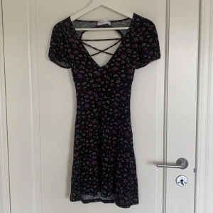 Svart blommig klänning - Svart klänning med blommor på. Ribbad. 