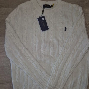 Kabelstickad tröja från Ralph Lauren - Fin kabelstickad tröja från Ralph Lauren i färgen vit, helt ny! Storlek S men passar även M. Hör av er vid frågor eller funderingar! 