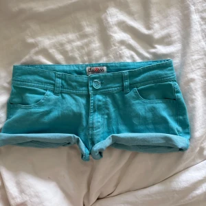 Vintage lågmidjade korta jeansshorts  - Säljer ett par korta Lågmidjade turkosa shorts från Chillin med uppvikta ben. Vintage så svåra att få tag på. Tar inte emot prisförslag under 500kr.💞