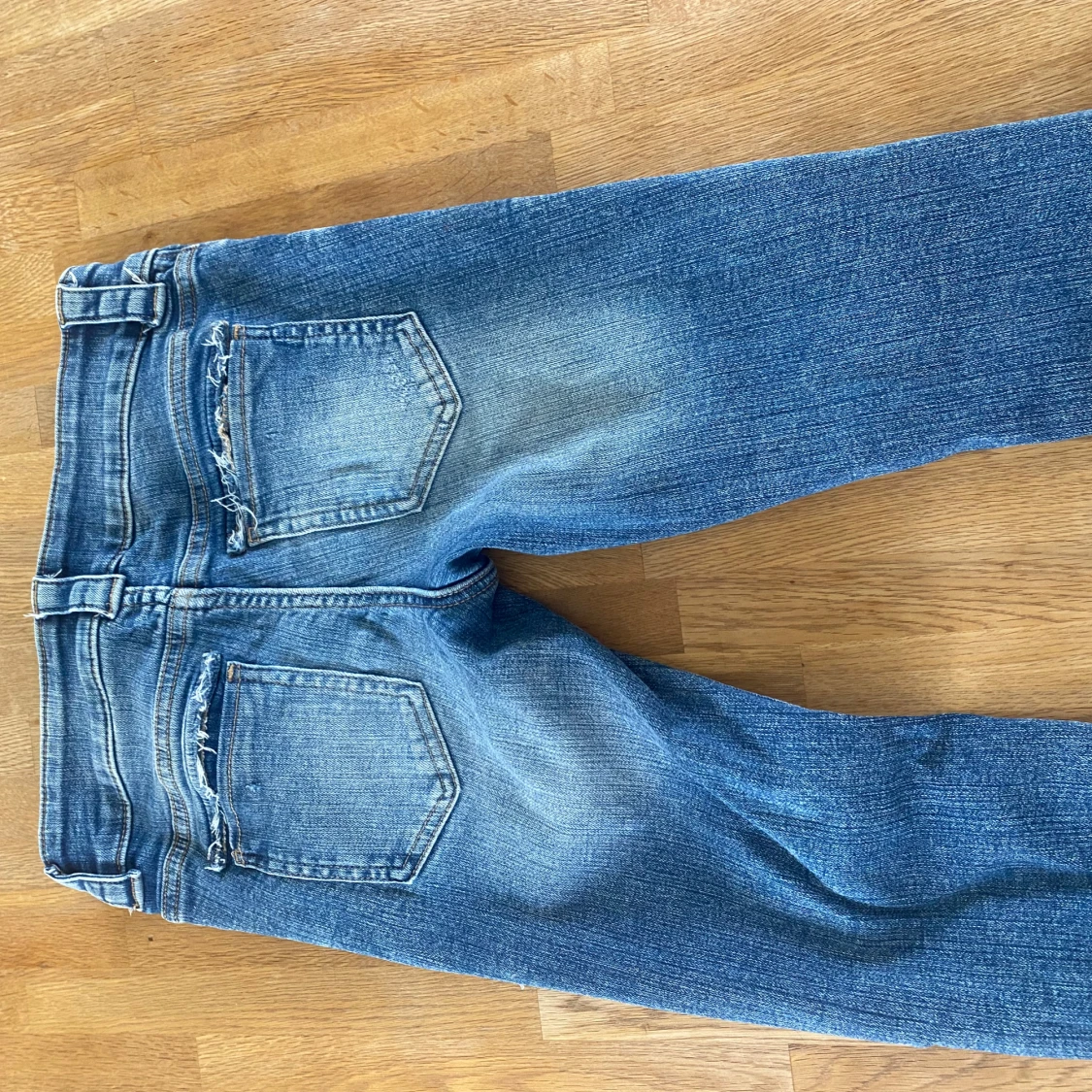 Blå slitna jeans med hål och knappar - 1