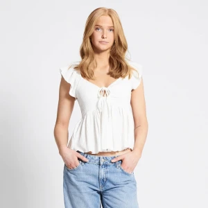 Vit croppad blus med knyt - Säljer en söt vit blus med korta ärmar och knyt framtill. Toppen är croppad och har en lätt volang nertill. Perfekt till jeans eller kjol för en fräsch look. Finns i storlek XS och S, kan mötas upp i stockholm eller frakta men står ej för frakten! Helt ny aldrig använd prislapp finns kvar, 