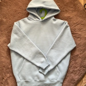 Ljusblå oversized hoodie från NewYorker - Säljer en ljusblå hoodie från NewYorker i oversized fit. Tröjan har huva, lång ärm och en stor magficka framtill. Perfekt för en avslappnad och stilren look. Materialet är mjukt och skönt mot huden.